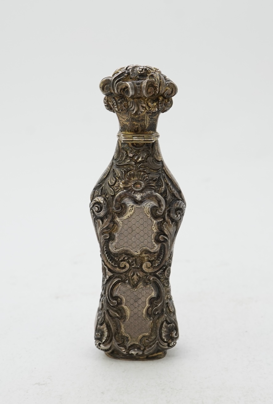 A 19th century French ornate parcel gilt white metal scent flask, with hinged cover and glass stopper